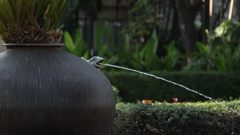Squirrel interacts with a water stream from a fountain