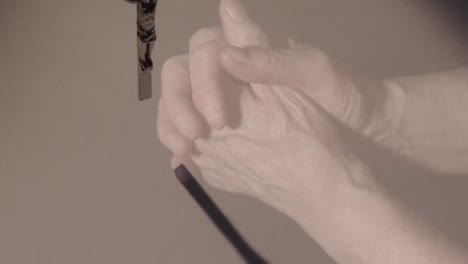 animation of hands of caucasian woman praying over cross