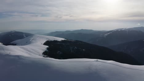 Serene-snow-covered-peaks-of-Saua-Gradisteanu,-Iezer-Papusa-Mountains,-with-soft-light-at-dusk