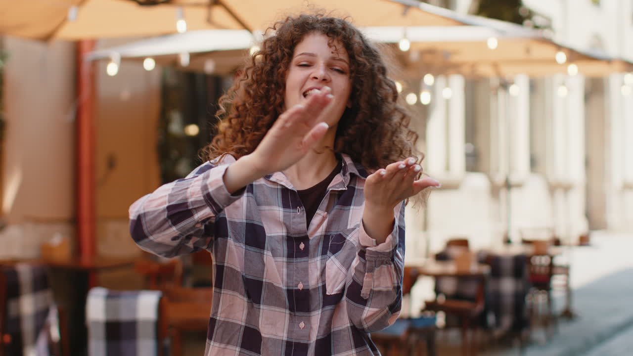 Cheerful rich woman showing wasting throwing money win lottery share celebrate in city street