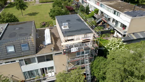 jib up of rooftop under construction and renovation in a green suburban neighborhood