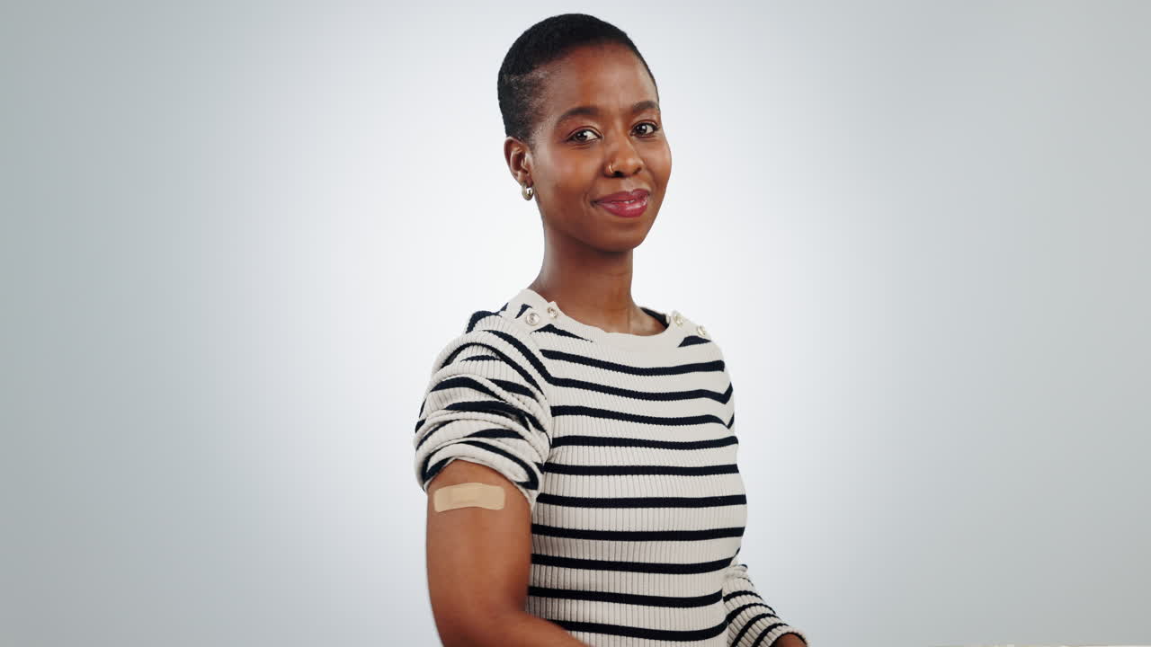 mujer, pulgares hacia arriba y vendaje para la vacuna