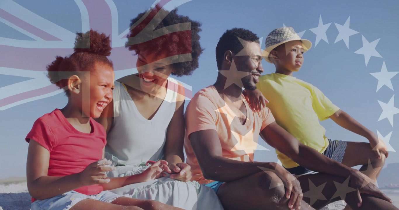 Familie im Strandurlaub: Mädchen schaufelt Sand und Junge zeigt auf Horizont, während Flaggen-Overlay eingeblendet wird