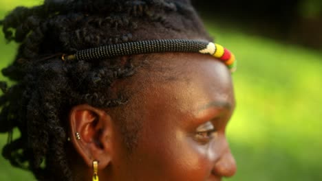 side view of a happy african woman from karamojong tribe in beaded headband and accessories