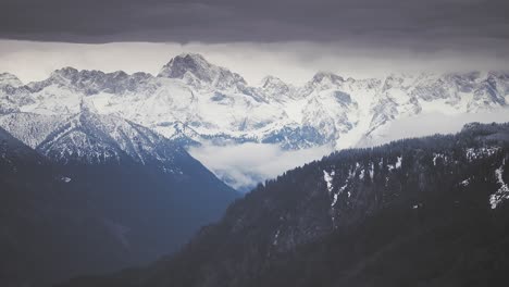 nubes oscuras y tormentosas giran sobre los picos nevados de los alpes austriacos.