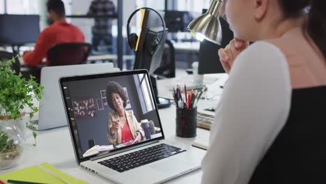 Mujer-Caucásica-Teniendo-Una-Videollamada-Con-Una-Colega-De-Oficina-En-Una-Computadora-Portátil-En-La-Oficina