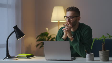 writer-or-journalist-is-writing-book-thinking-and-typing-in-laptop-working-in-home-sitting-in-cozy-room-portrait-of-man-with-glasses