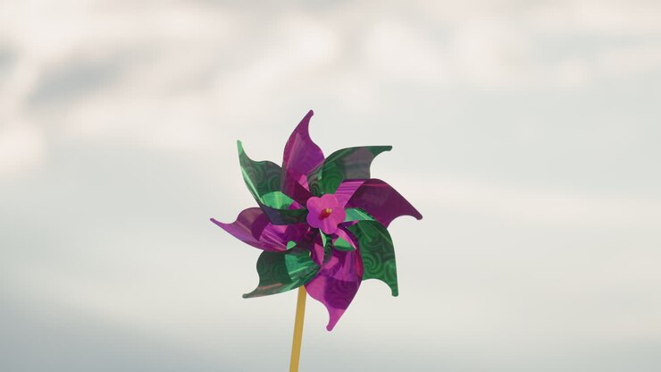 Close up of colourful pinwheel rotating vigorously under cloudy sky motion blur capturing whimsical movement and soft ambient light against overcast backdrop