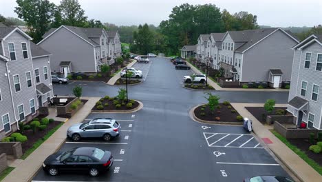 quiet neighborhood of american suburbia with parking cars. new modern houses with grey facade. cloudy autumnal day in usa. aerial dolly forward shot.