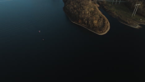 Aerial-drone-shot-of-Flint-Creek-lake,-tilt-up-reveal-nearby-power-plant