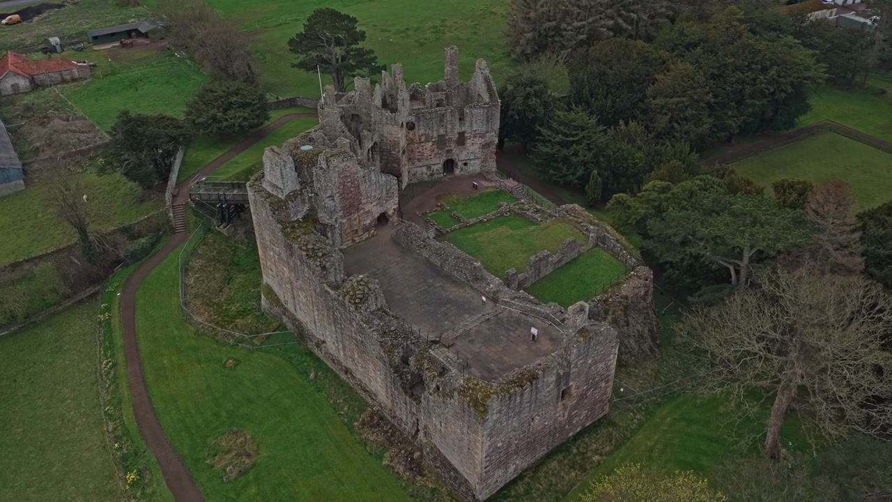 Vista aerea dello storico Castello di Dirleton, le rovine di una fortezza medievale nell'East Lothian, Scozia, che mette in risalto la sua architettura antica.
