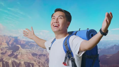 close up side view of asian male hiker with mountaineering backpack spreading arms enjoy looking the view around while traveling at the top of mountain