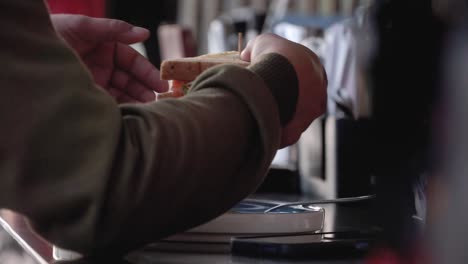 Close-up-shot-hand-of-people-hold-the-sandwich-and-and-brought-the-food-to-his-mouth