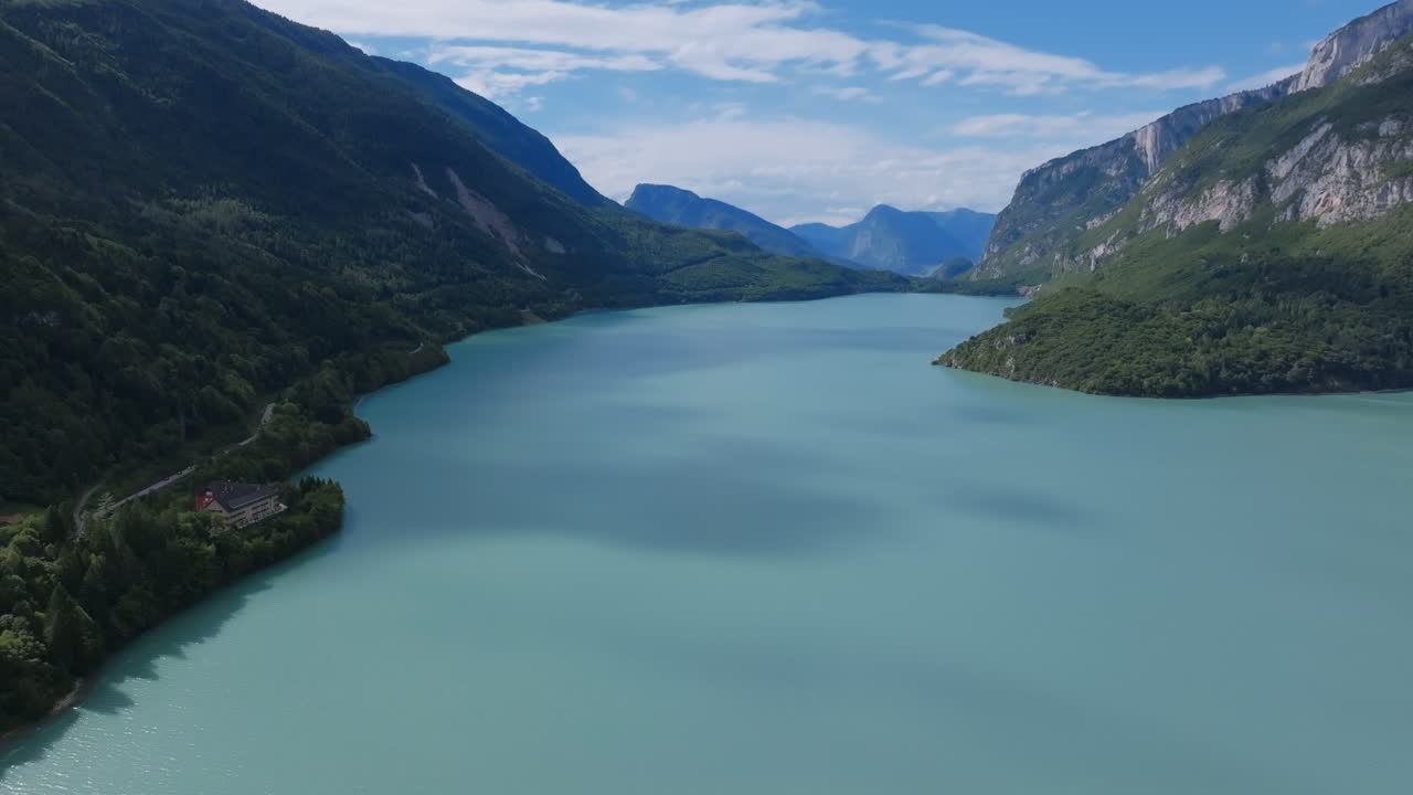 Aerial footage slowly flying over the turquoise colored lake of Molveno in northern Italy.