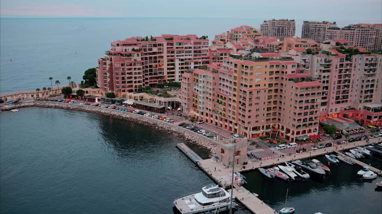 Aerial view of boats docked in the Port de Fontvieille with the skyline of Monaco on the background in the evening