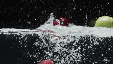 video van appels die in het water vallen met kopieerruimte op zwarte achtergrond