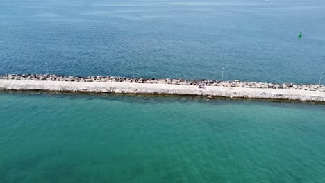 drone footage of a breakwater close to the harbor