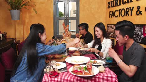 group of young friends enjoying meal in restaurant, video 4k
