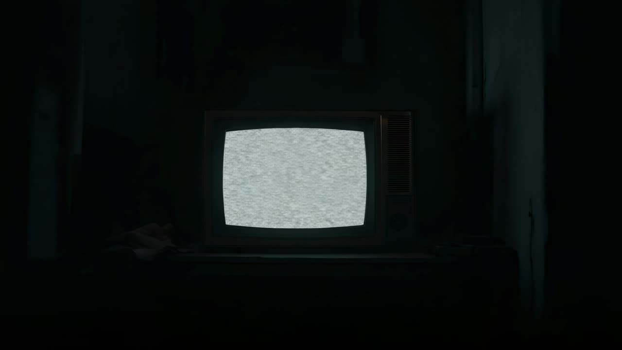 CRT television receiving power and displaying static pulses in dimly lit room, with power cable
