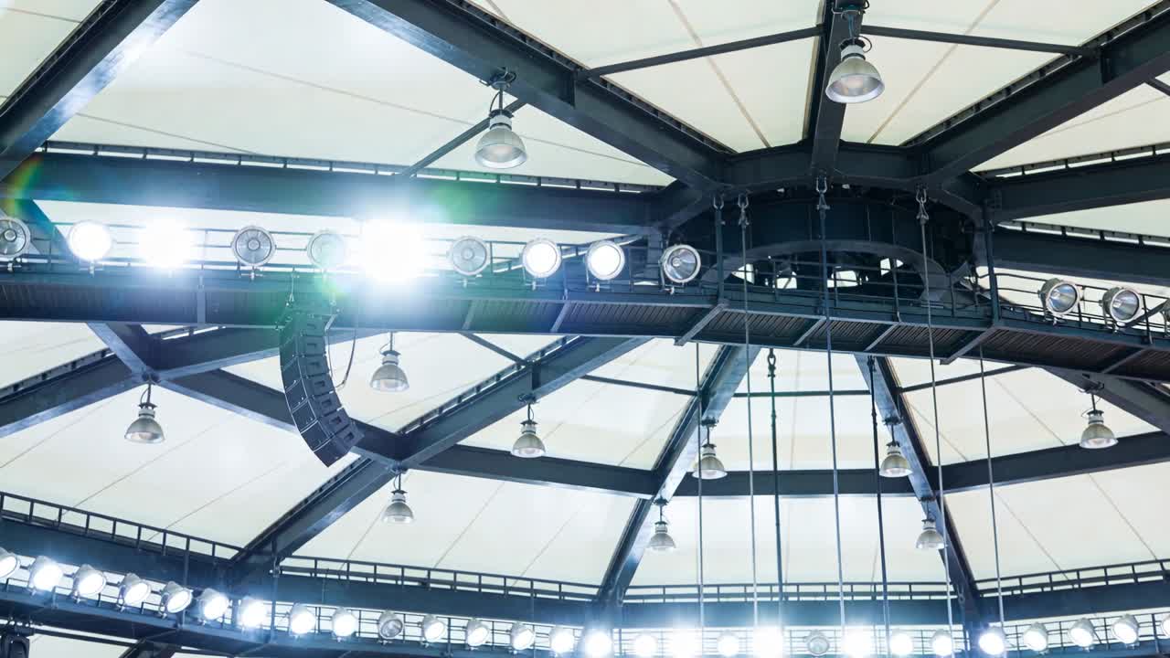 Showing central dome hub lighting rig brightening after lighting cue in arena, with ring fixtures