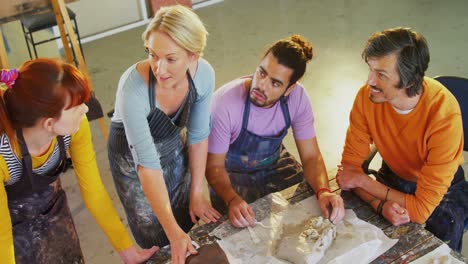 drawing teacher assisting artists in molding clay 4k