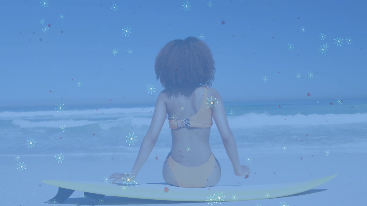 woman sitting on surfboard at shoreline, displaying health analytics overlay with heart icons