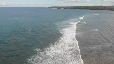 Vista-Aérea-De-Drones-De-Surfistas-Esperando-La-Ola-Perfecta-En-La-Isla-Paradisíaca-De-Siargao-En-Filipinas