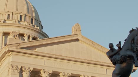 tilt and pan of the tribute to range raiders statue on the ground of the oklahoma state capitol to the capitol dome