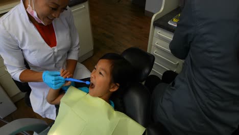 female dentist examining a girl patient 4k