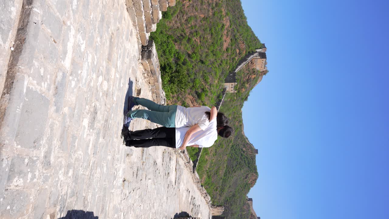 Happy couple kissing and hugging in the Chinese Great Wall. Vertical