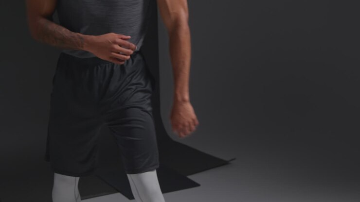 Close Up Studio Shot Of Male Boxer Training Warming Up In Gym Preparing For Fight Against Black Background
