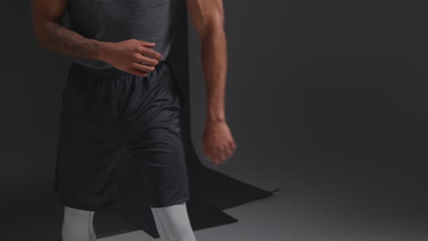 close up studio shot of male boxer training warming up in gym preparing for fight against black background