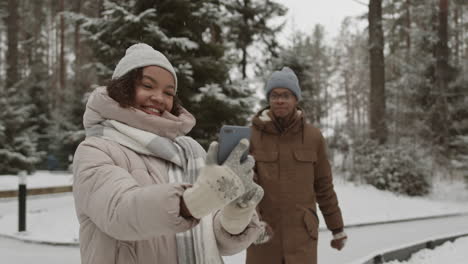 amigos tomando selfies en el parque nevado