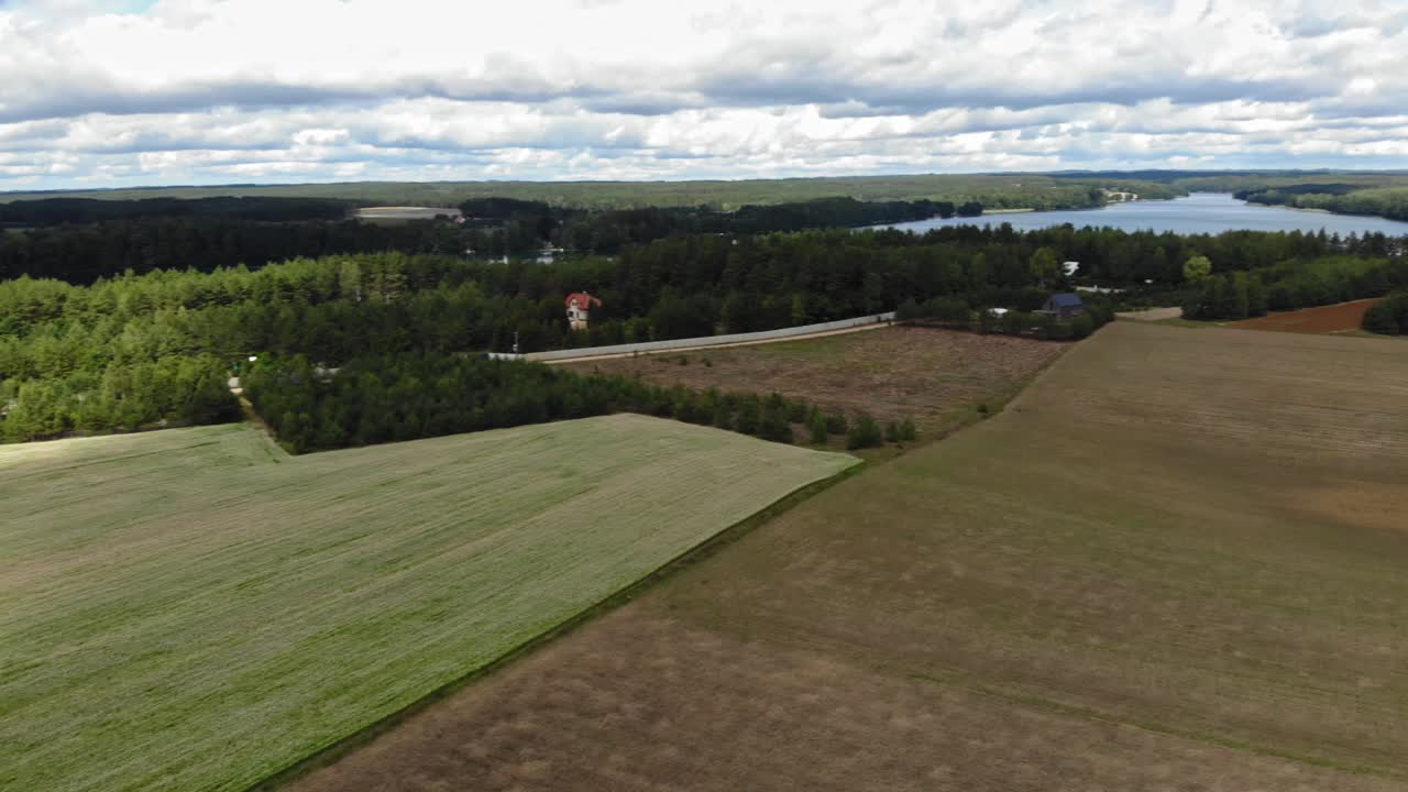 vista aérea de campos de cultivo y un lago en el área rural de borowy młyn en kashubia, voivodato de pomerania, polonia