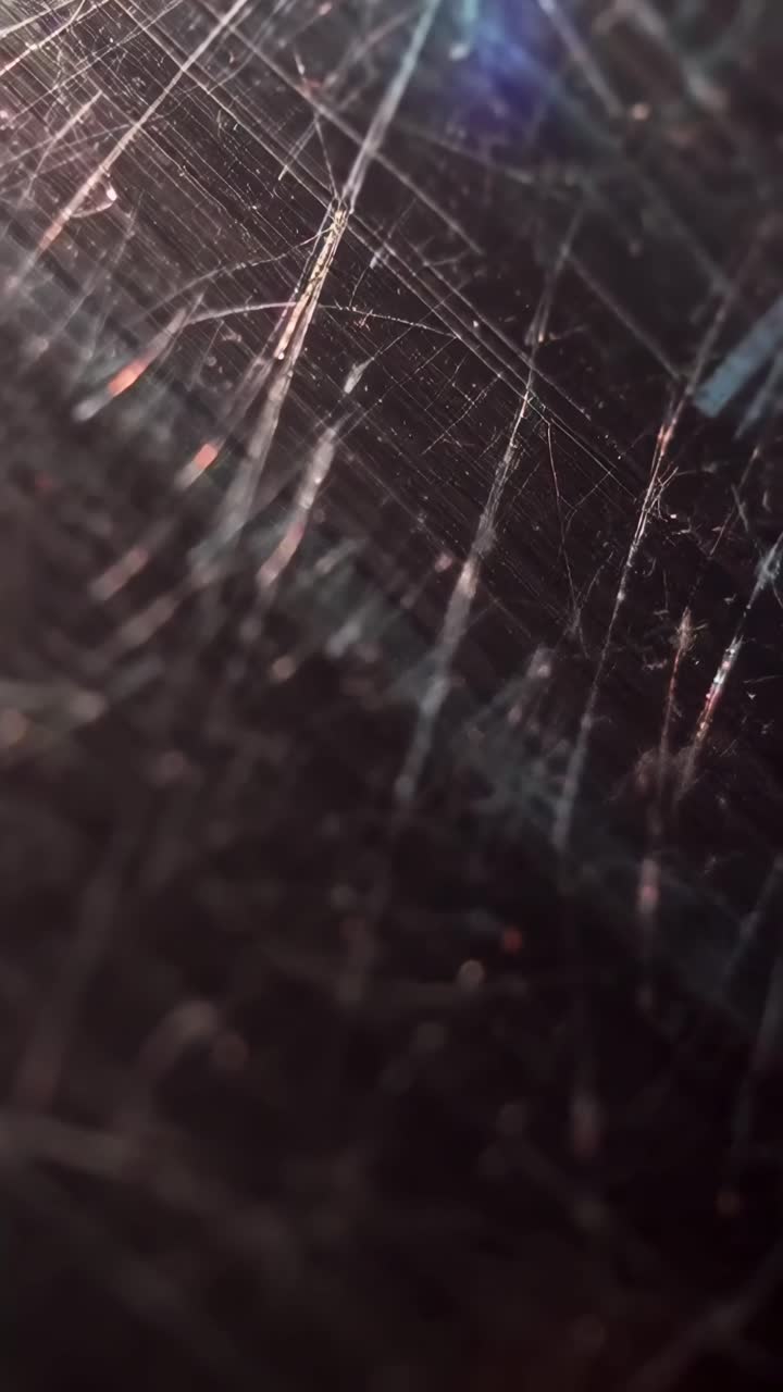 Close-up video of scratched metal surface, capturing intricate textures at an oblique angle