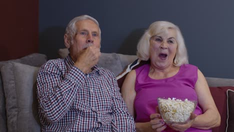 overjoyed old mature couple football fans watching sport tv game support cheer winning soccer team