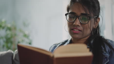 indian woman flips pages of textbook looking for information