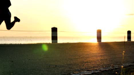 blurred motion male runner running in the nature the time during sunrise on dam road exercise. healthy lifestyle. slow motion