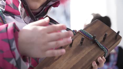 child playing a traditional wooden instrument