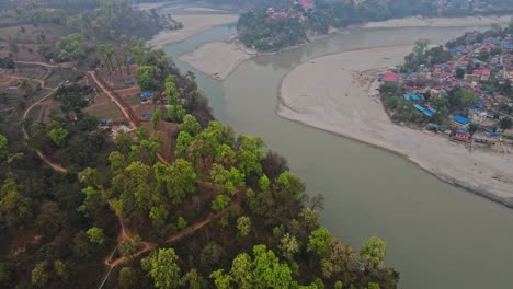 drone footage captures the peaceful landscape of devdaha in chitwan, nepal, showcasing farmlands, rural homes, and surrounding greenery under the vast sky — a glimpse into quiet nepali village life
