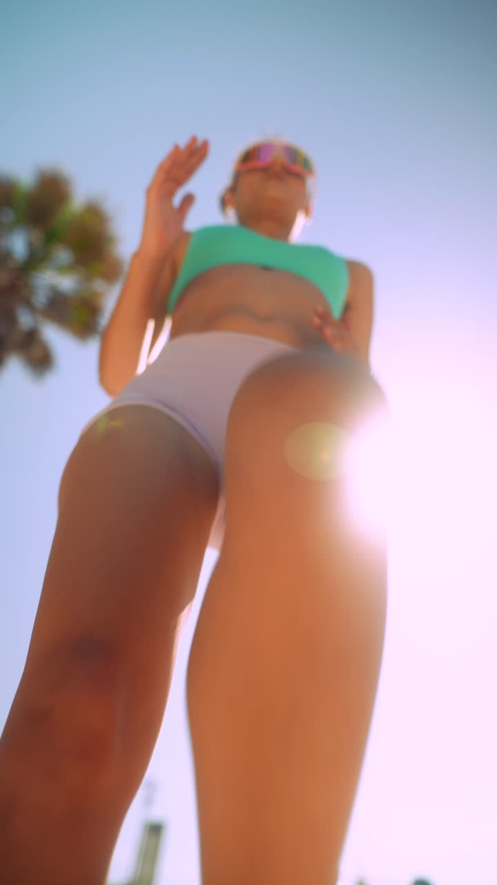 Mujer joven enérgica bailando y posando al aire libre
