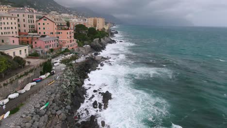 Rough-sea-waves-near-coastline-of-Genoa,-day-with-stormy-clouds,-cinematic-aerial-view