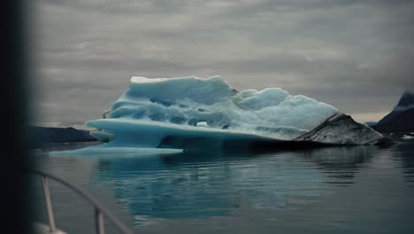 Sailing-towards-a-beautiful-ice-block-in-icy-water,-outside-Nuuk-Greenland