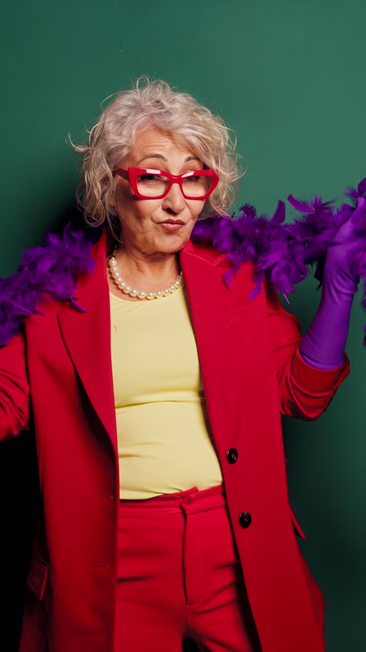 Elegante signora anziana in posa con boa di piume viola