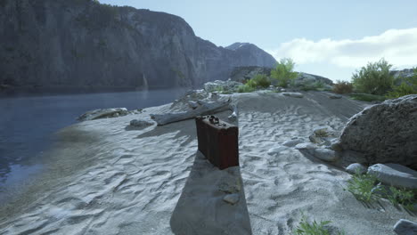 a vintage suitcase sits on a sandy beach with a mountain backdrop