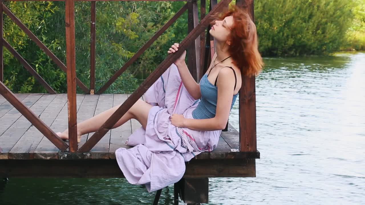 Woman sitting on a pier by a lake
