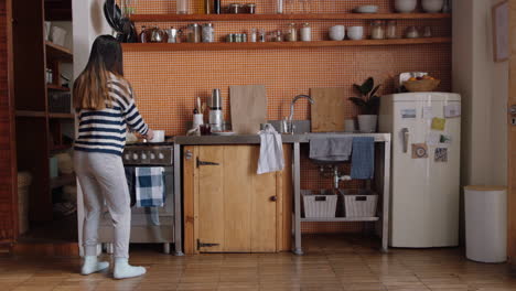 happy asian woman dancing in kitchen celebrating successful lifestyle enjoying cheerful victory dance celebration at home on weekend