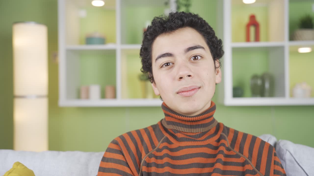 un chico gracioso y simpático mirando a la cámara en casa haciendo movimientos raros y divertidos.