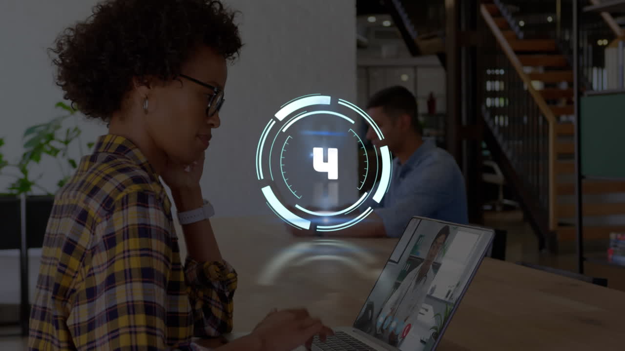 Animation of countdown over african american businesswoman having laptop video call with doctor