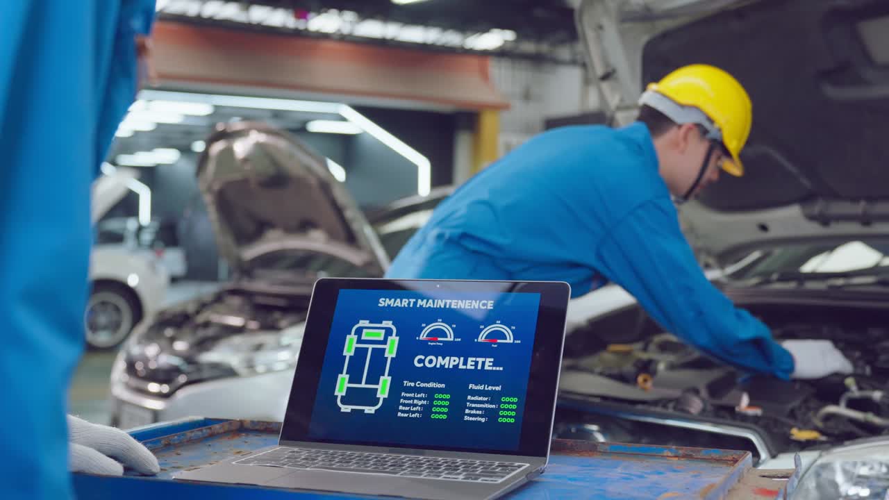 Close up of Automotive mechanic running diagnostics software on tablet. Asian young vehicle service manager worker work in mechanics garage, check and maintenance to repair the engine car in workshop.